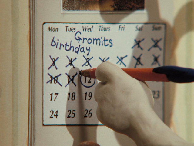 A clay dog's hand uses a pencil to cross out a date on the calendar, the 12th. It's labeled "Gromits birthday"