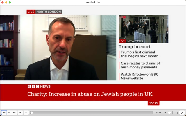 The image appears to be a screenshot of a news report. There's a man in the center, who is speaking or being interviewed. He has graying hair and is wearing a suit with no tie, suggesting a casual or formal setting without overly strict dress code. At the top left corner, there's a "Live North London" label, indicating that this might be an ongoing broadcast from North London. The text at the bottom of the image, which includes phrases like "Charity increases in abuse on Jewish people in UK" and other headlines suggesting political or social news events, indicates that the report is likely related to current affairs or issues affecting the United Kingdom. On the right side of the image, there's a thumbnail for another video with the headline "Trump in court case begins next month," which suggests coverage of legal proceedings involving former U.S. President Donald Trump. Additionally, there are other headlines visible on the screen that pertain to various topics, such as health concerns and crime statistics. The interface elements suggest this is a digital broadcast or live streaming platform, possibly from the BBC News website based on the URL in the top left corner. The overall image conveys a sense of professional journalism covering diverse topics relevant to current events.
