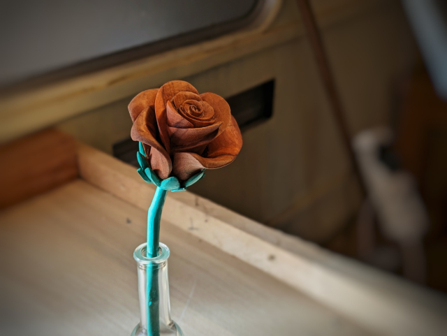 Sculpture d'une rose dans une petite bouteille en verre 