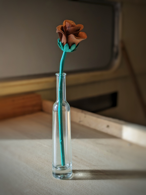 Sculpture d'une rose dans une petite bouteille en verre 