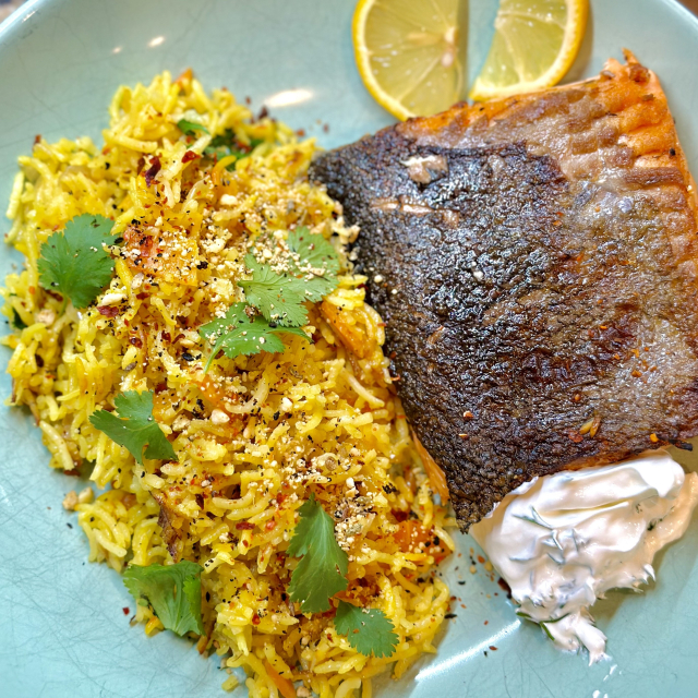 A photo of saffron rice with a side of salmon and labneh with dill