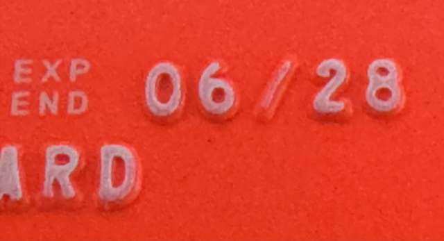Close-up of an expiration date embossed on a red surface, reading "EXP END 06/28".
