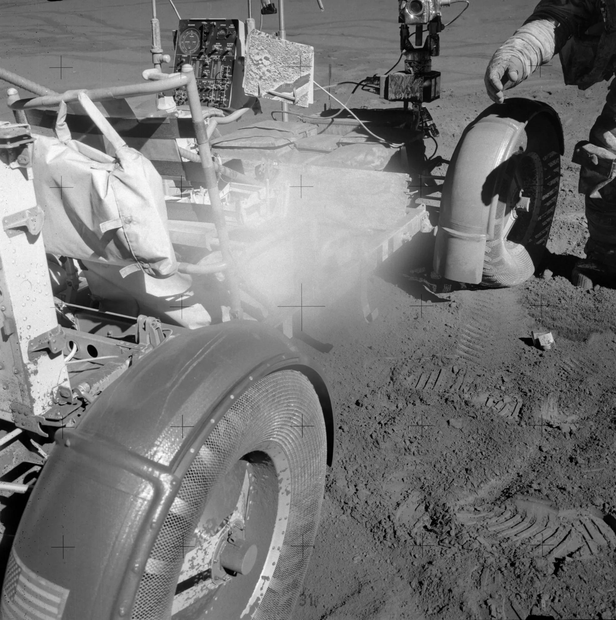 Dust covers the central part of the lens in this photograph, obscuring the subject. The photo is of a dust-covered lunar rover. Dust can be seen caking the wheel rims and bodywork, as well as the astronaut’s suit in the top right of the image. https://www.nasa.gov/history/alsj/picture.html