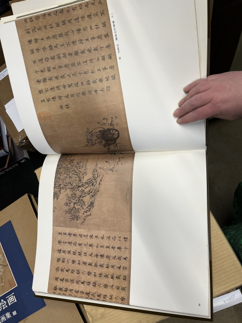 A sample two-page spread in the book, showing a scroll with a painting and writing in Chinese. 