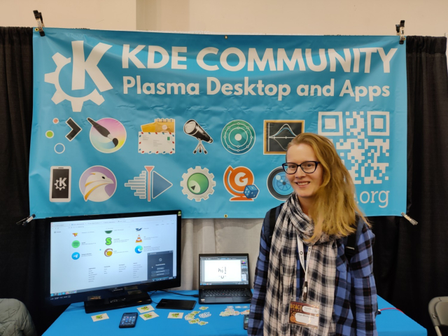 An attendee to SCaLE20x poses in front of the KDE booth.