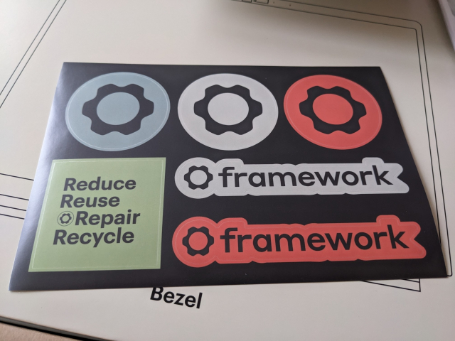 Stickers with Framework logo (a cogwheel), and one with the words "Reduce Reuse Repair Recycle".