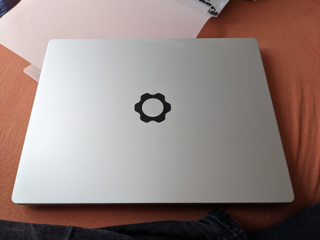 A silver notebook lid with the cogwheel symbol on it.