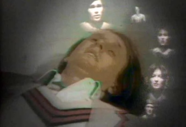 5th Dr Who Peter Davison on floor eyes closed regenerating with faces of past companions around him 