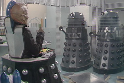 David, facing two Battle Daleks in a misted environment 