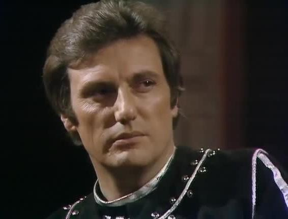 Microsoft Azure's Computer Vision API describes the image as "Paul Darrow with a serious expression" with a confidence of 41%.

ChatGPT4 describes the image as: "The image shows a person with a serious expression, featuring short, dark hair and prominent cheekbones. They appear to be wearing a dark, perhaps historical or costume-looking outfit with distinctive, possibly metallic, trim or piping on it. The background is dimly lit, suggesting the setting could be indoors with controlled lighting, possibly from a television or film set."

Blakes7Bot, version 3.4.80.