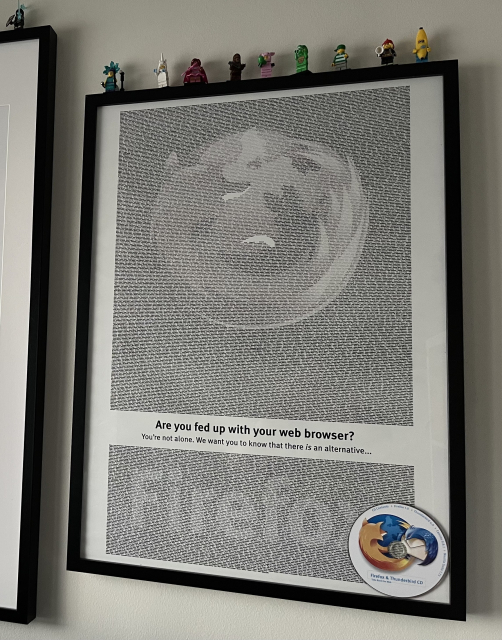 A framed copy of the ad for Firefox 1.0 with a CD-ROM attached in the corner 