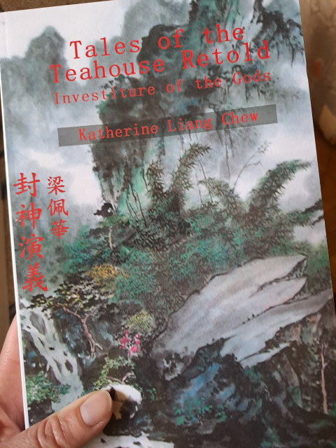 The cover of the book shows a Chinese style painting of a forest landscape. The title says "Tales of the teahouse retold: Investiture of the Gods." By Katherine Liang Chew