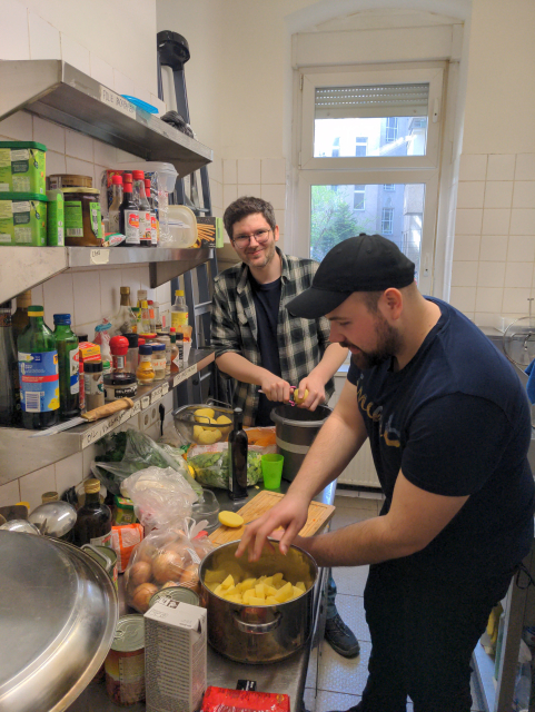 People cooking in a tiny kitchen.