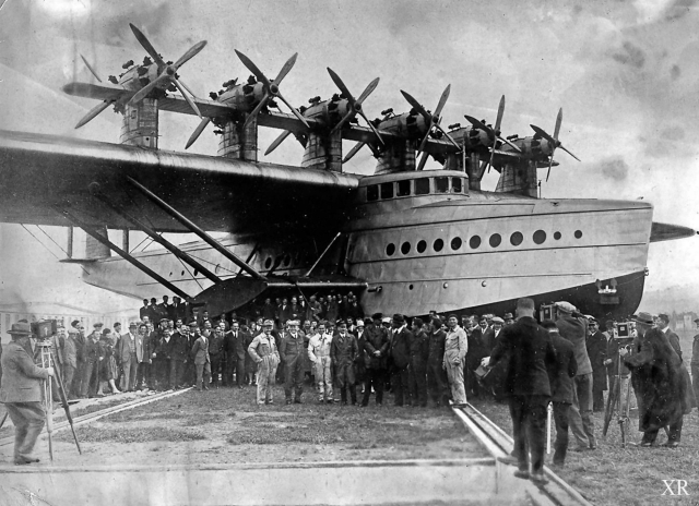 A big plane that's also a boat with twelve propellers mounted in a row on top of its wings