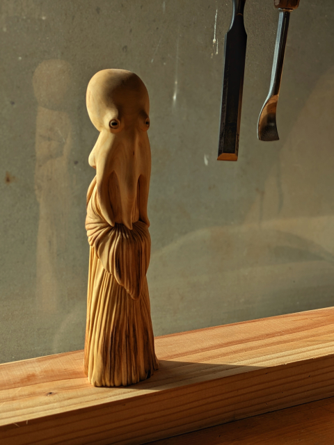 Woodcarved opus humanoid  wearing a dress that never saw an iron