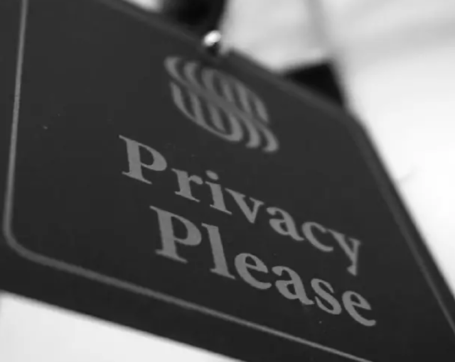 Black and white picture of a sign that says Privacy Please. 