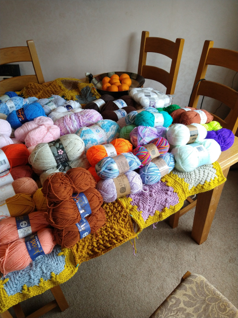 Dining table covered in various colours of yarn 