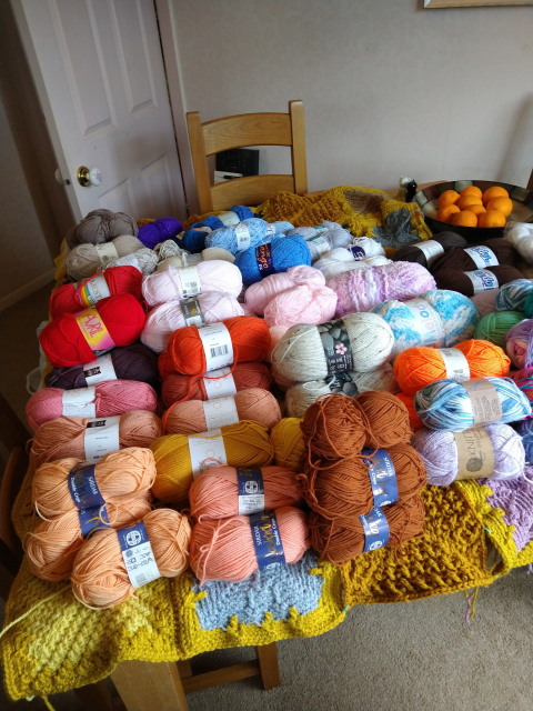 Dining table covered in various colours of yarn 