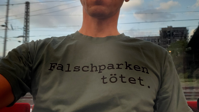 Oberkörper eines Menschen mit einem T-Shirt. Aufschrift: "Falschparken tötet."