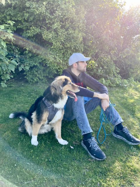 My dog and I sitting on the grass and looking to the side