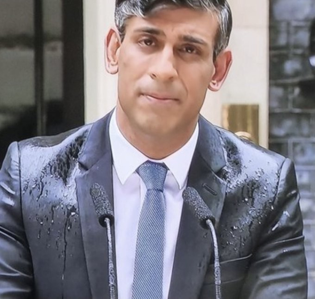 A freeze frame or Rishi Sunak, hopefully the former Prime Minister of the United Kingdom, getting rained on at a lectern in front of 10 Downing Street, while announcing the 2024 General Election.