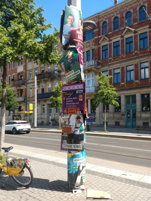 Eine Säule mit vielen beschädigten Wahlplakaten, die zusammen gebaut wurden. Zu erkennen sind Plakate der Grünen, der SPD und von uns Piraten.