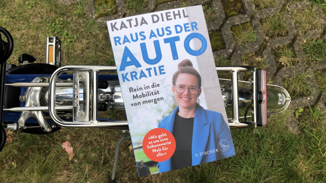 Das Buch „Raus aus der Autokratie” von Katja Diehl auf dem Gepäckträger meines Fahrrades liegend.