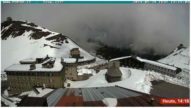 Stelvio - pohled z webkamery na zasněžené vrcholky.