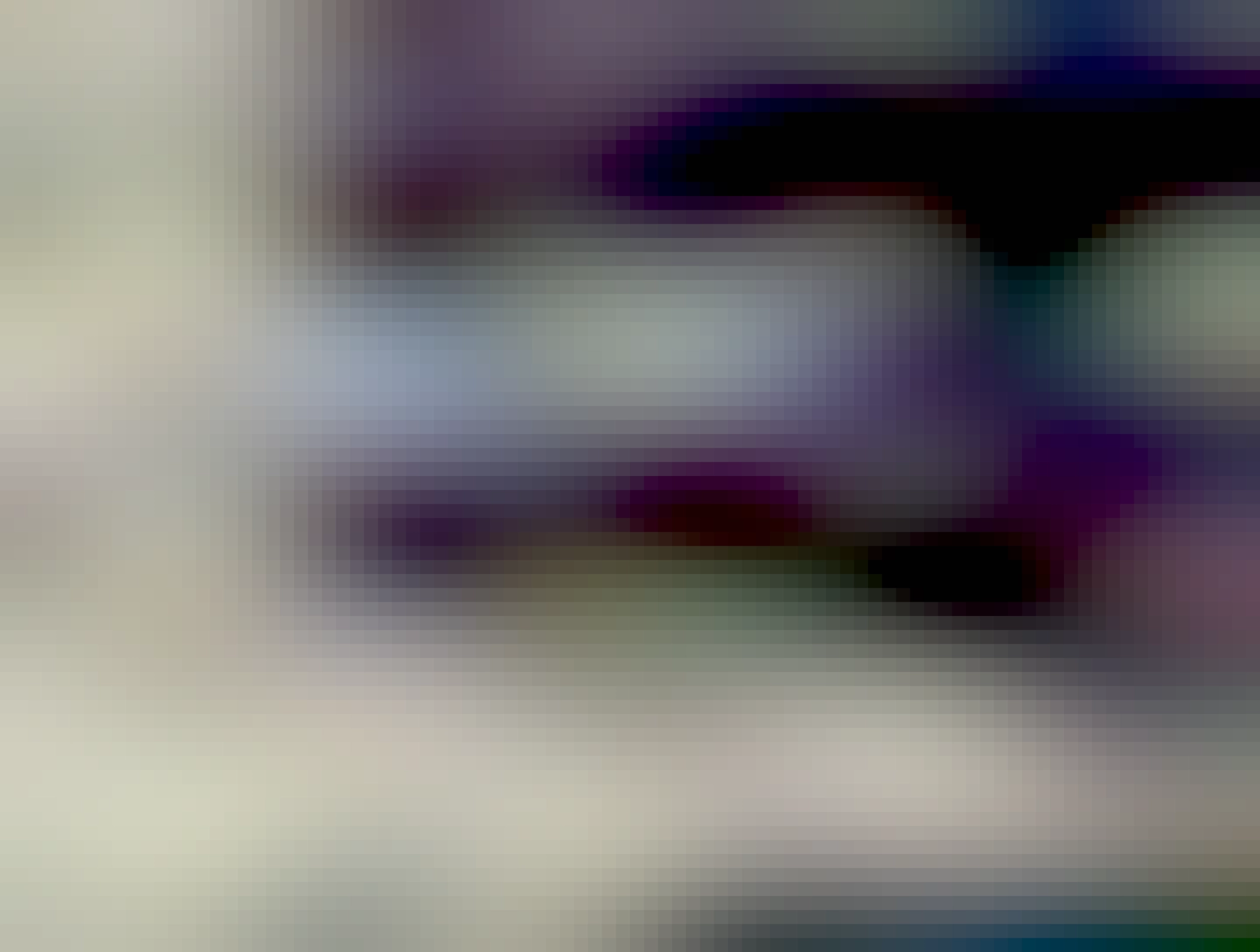 A narrow pavement under a bridge. The road is clogged with cars 