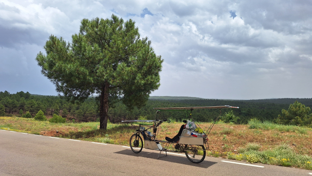 Solar bike parked at solitary tree under cloudy sky after storm