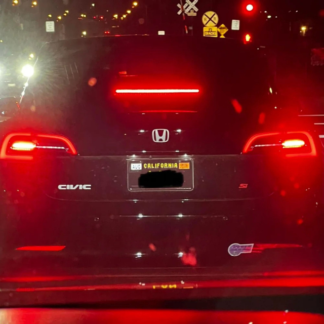 A Tesla where the owner has removed the Tesla badges and put on a Honda logo, Civic badge, and "Si" badge