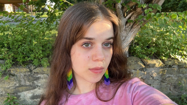 Tzipporah in a pink shirt and rainbow beaded fringe earrings