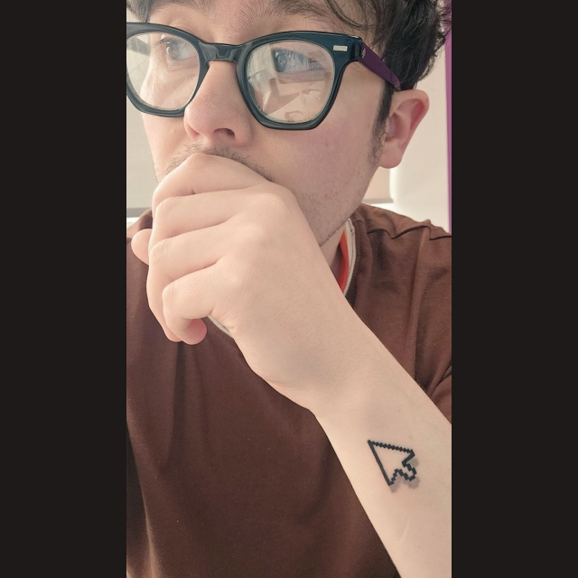 A specky guy with a mouse cursor tattoo on his arm