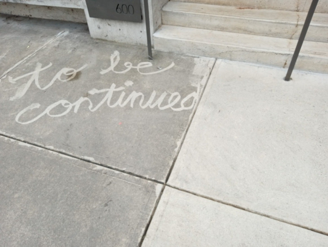 clean 'to be continued' written on dirty sidewalk