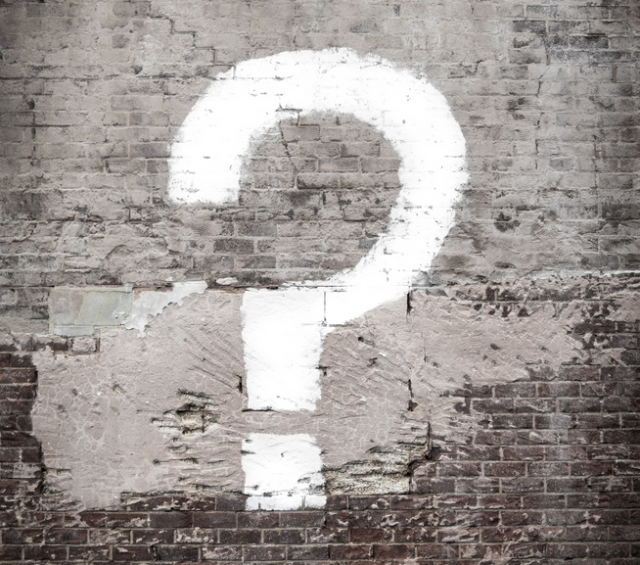 A question mark painted onto a brick wall. (Photo by Matt Walsh on Unsplash)