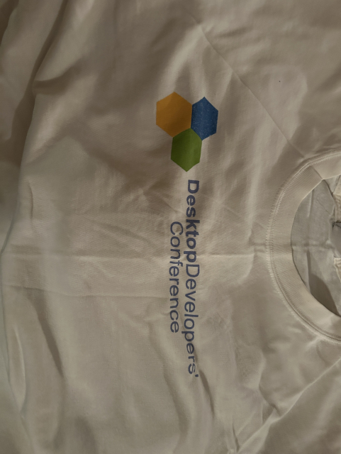 Picture of a white t-shirt with the logo of the Desktop Developer Conference. (Not pictured: 2006)