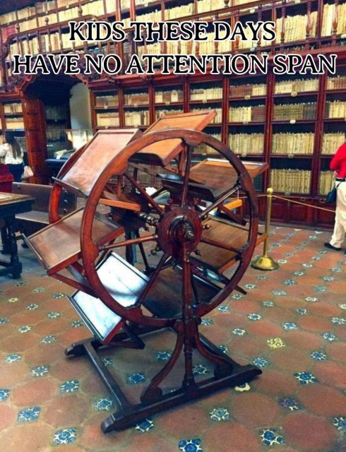 A photograph of a book wheel designed to allow a reader to have 7 books open at once, located in a university library. It's clearly quite old, made from well polished wood and likely meant for having many books open while writing and requiring multiple references.

Over top of the photo in black and white text is the statement "Kids these days have no attention span".