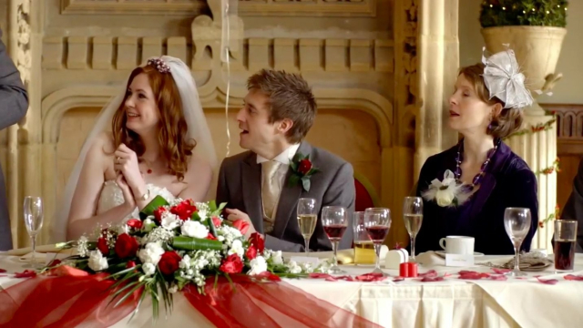 A bride and groom sitting at a wedding head table