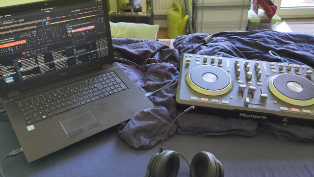 In bed with a laptop running the Mixxx DJ Software, headphones and a mp3 controller.