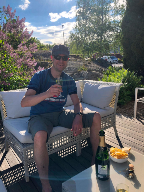 Daniel outside in the sun with a champagne glass in hand.