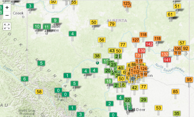 Map of central & northern Alberta from aqicn.org, with coloured flags showing air quality readings using the US EPA scale. There is an approximate diagonal division passing from the northwest to the southeast, running through the Edmonton area in the middle: the the south and west of the line, polution readings are all very low, in green. To the north and east, readings are marked in yellow and orange, up to 142 AQI. (Which is still much, much less than the worst it gets.)