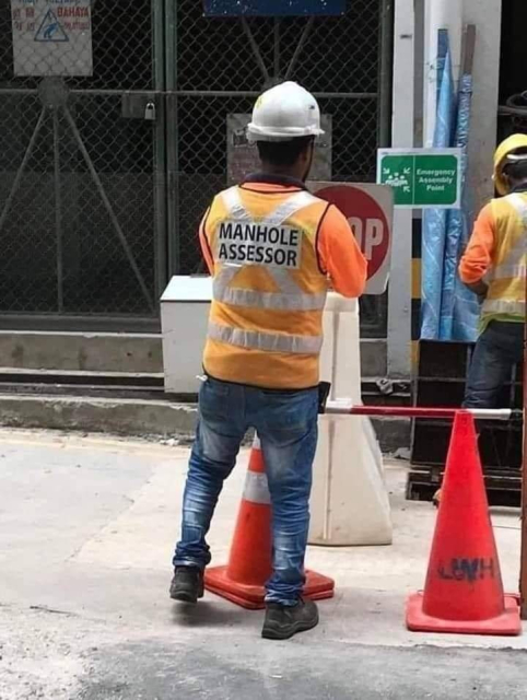 A construction worker wearing a vest that says:

Manhole Assessor 