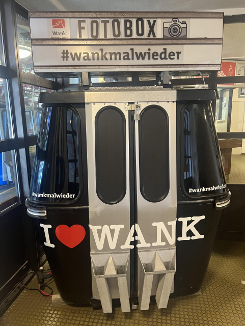 A cable car wagon set up as a photo backdrop. There’s text “#wankmalwieder” and “I (heart) WANK”