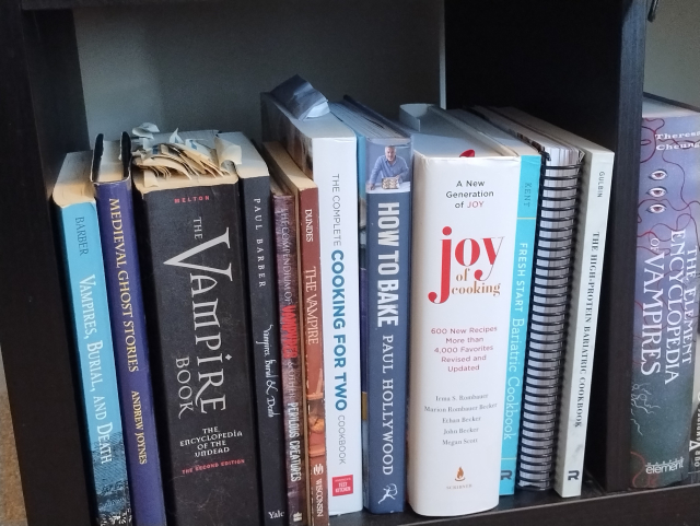 Vampire books and cookbooks side by side on a shelf.