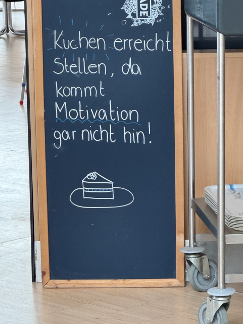 Ein Schild mit dem Spruch: "Kuchen erreicht Stellen, da kommt Motivation gar nicht hin!"