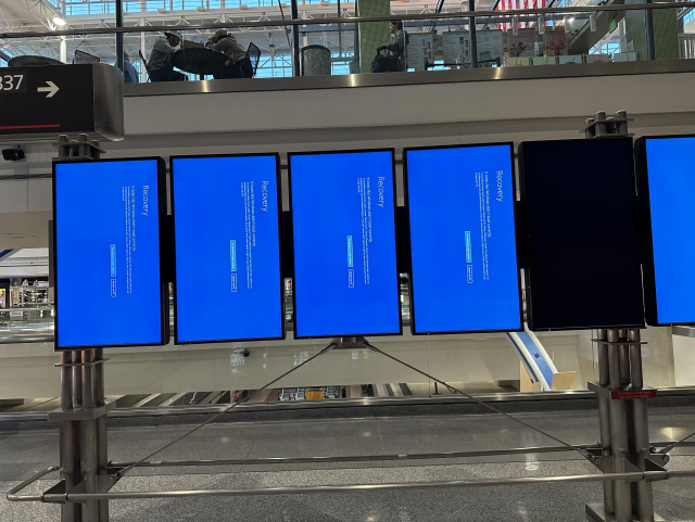 A bank of flight info displays at Denver Airport all blue screened by the failed Crowdstrike update.
