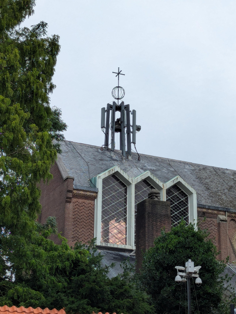 A church like building with a bunch of microwave antennas on top