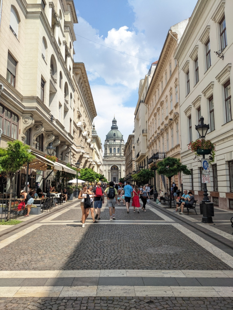 A cobblestone street leading up to a domed church.