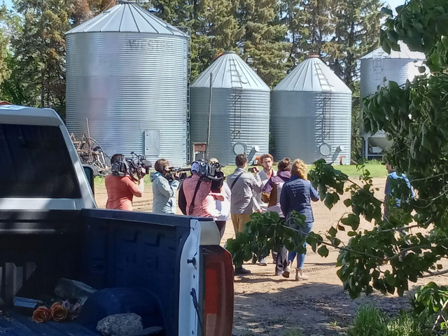 A crowd of journalists, most carrying TV cameras, following the engineers across the yard of the farm, past a big truck and some grain bins.  This was when they finally admitted they were from SpaceX.  
