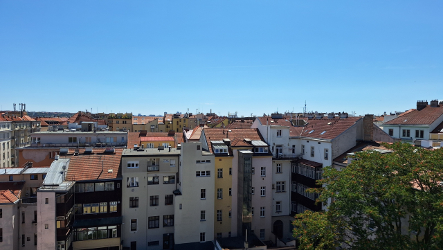 Blue sky over city with mostly red roofs. Quiz for my followers.